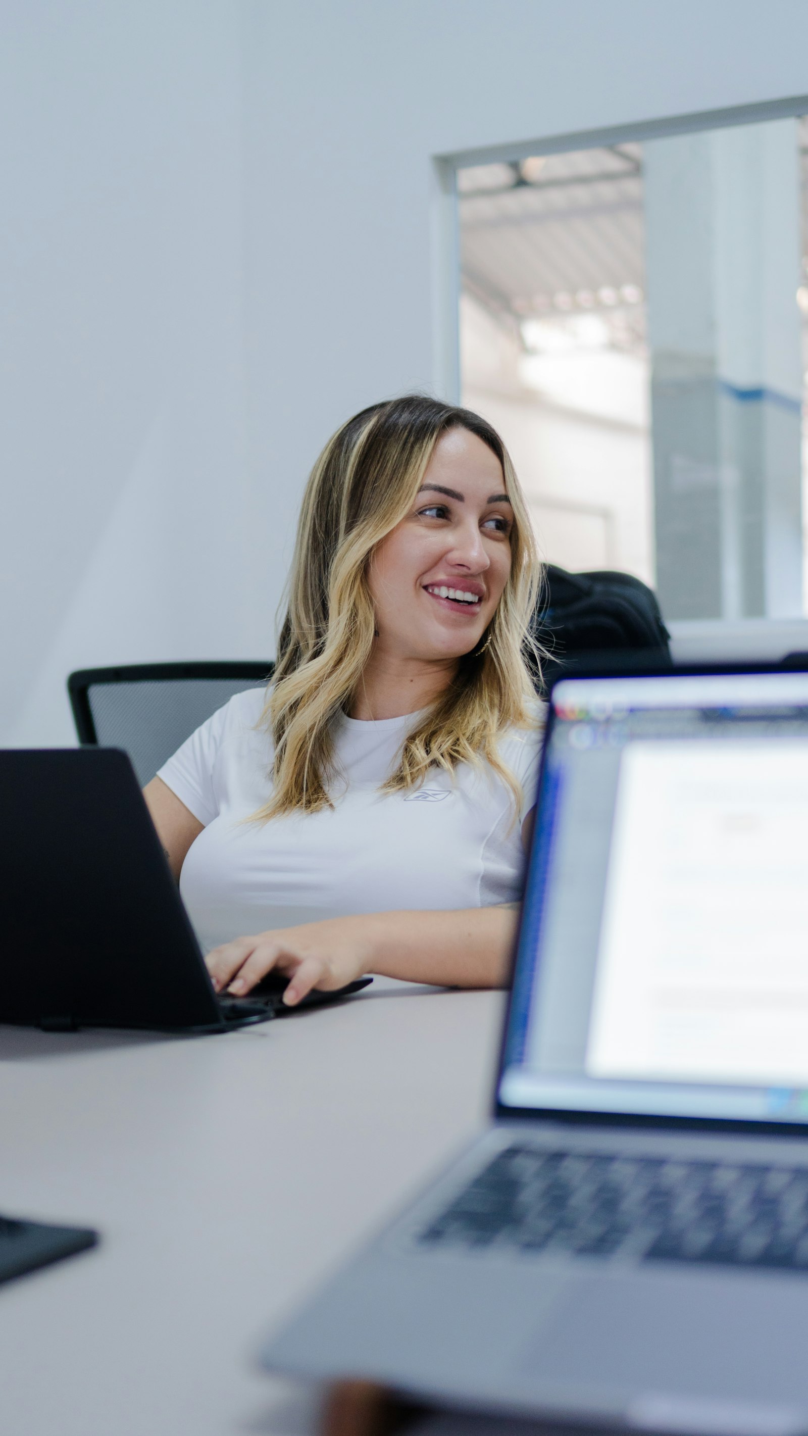 Empreendedora sorrindo tranquilamente diante do notebook, sem o estresse da planilha manual